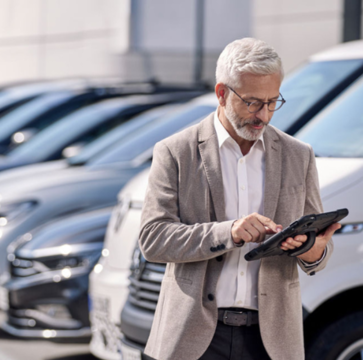 Gesch&auml;ftsmann Tablet auf Parkplatz