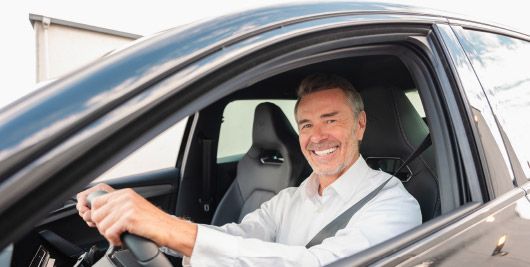 Gesch&auml;ftsmann freut sich &uuml;ber Gewerbeleasing-Fahrzeug