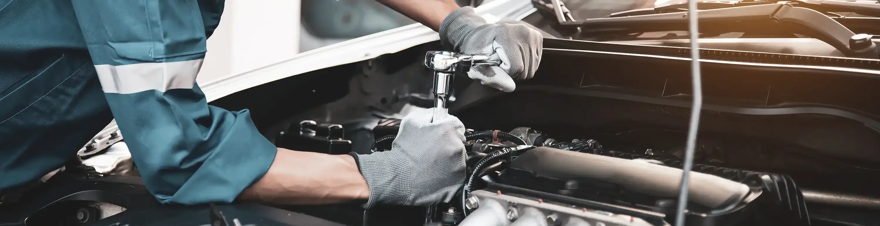 Mann repariert professionell ein Firmenfahrzeug in einer ausgezeichneten Werkstatt