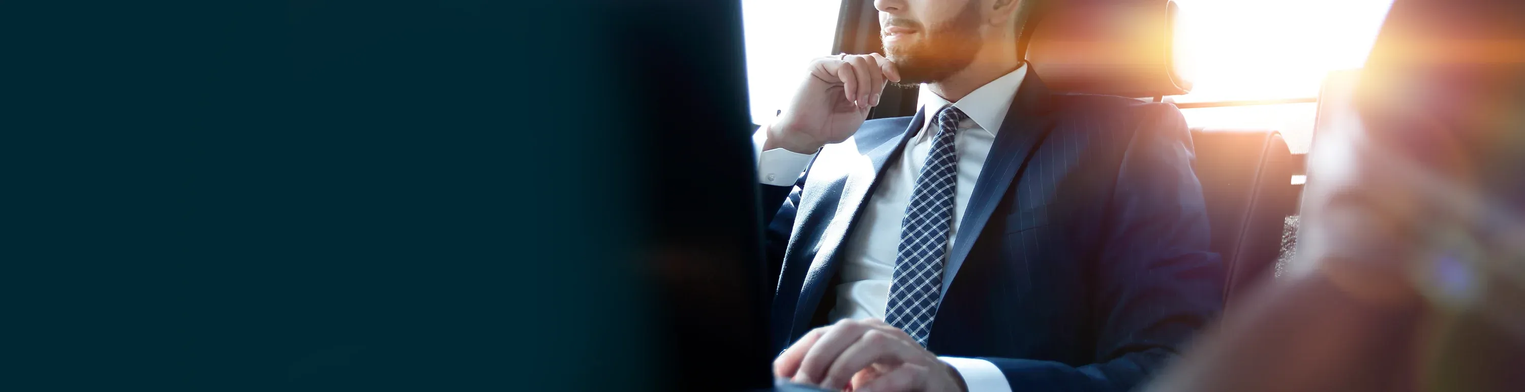 Gesch&auml;ftsmann im Anzug sitz im Auto und denkt &uuml;ber Leasing, Finanzierung und Versicherung seiner Firmenfahrzeuge nach